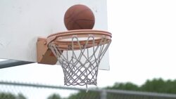 Basketball going into outdoor basketball hoop. Stock Footage