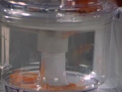 Woman cutting carrot in blender Stock Footage