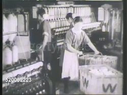 1942: JAPAN: LOOM FACTORY: WS Apartment buildings in city. WS Gate w/ male pulling horse drawn cart. INT VS Loom factory workers pushing materials in basket carts, females working on loom machines, weaving cloth. Home front Instructional Video
