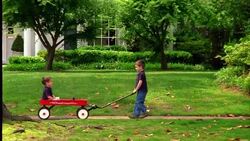 A boy pulls his brother in a wagon. Stock Footage