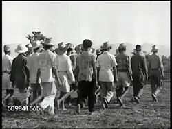1945: PHILIPPINE GUERRILLAS: WS Camps in hill, mountains BG. WS Philippine guerrilla members doing marching drill. MS Guerillas soldiers lined up. VS CU Soldiers. VS Man demonstrating, instructing rifle, soldiers around. Instructional Video