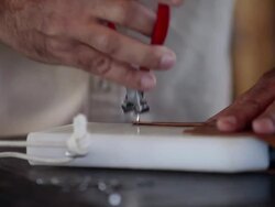 CU PAN TD R/F boot maker standing at counter in workshop removing vamp of cowboy boots from stretcher Stock Footage