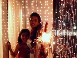 Young woman celebrating diwali festival with her daughter Stock Footage