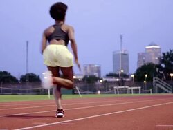 MS to WS female athlete running on track away from camera  Stock Footage