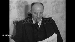 1937: GERMAN FAMILY: DRAMATIZATION: Male, father reading paper. Woman, mother, sewing material separation. CU Female hand placing lard butter in bowl. Female teen scraping plate into pig scraps box.  [Ich Esse (I eat) w/ list of what can go into box] Instructional Video