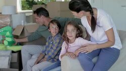 Family on sofa surrounded by moving boxes Stock Footage