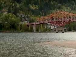 A long orange bridge connecting the two sides of a river Stock Footage