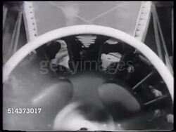 1929: PRIVATE AIRCRAFT: VS Group of friends by airplane outside hangar, man turning propeller, CU Turning propellers, WS TRACKING Aircraft taxiing, aircraft not stable, rocking side to side, wing tip catching ground, turning, landing upright in dirt. Instructional Video