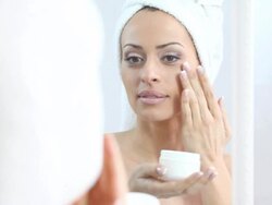 Woman using skin moisturizer. Stock Footage