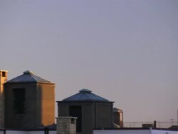 A variety of water towers contrast against a pale blue sky in New York City. Stock Footage