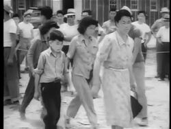 B/W 1942/3 PAN Japanese-Americans exiting bus in internment camp / documentary Stock Footage