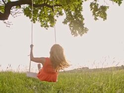 SLO MO Cheerful girl swinging on tree swing Stock Footage