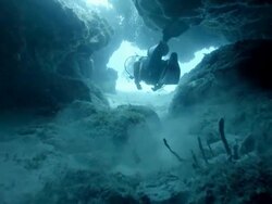 WS Divers swimming through cave in coral reef Stock Footage