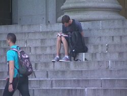 A Man Reads a Book While Sitting On Church Steps Stock Footage