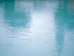 Rain falling on water surface Stock Footage