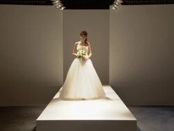 WS Woman modeling wedding dress and holding bouquet of flowers on catwalk / London, England, UK Stock Footage