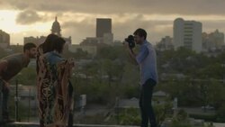 Young man shoots footage of friends with vintage film camera on rooftop overlooking downtown Austin, Texas Stock Footage