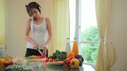Young woman cooking in kitchen and listen music Stock Footage