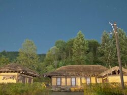 WS T/L LA View of traditional thatched house (birthplace of  novelist in Korea named Ihyoseok) and star in  night sky / Pyeongchang, Gangwon do, South Korea Stock Footage