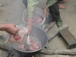 MS cooking meat over a fire / Xam Neua, Laos Stock Footage