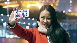 pretty asian girl taking photo with smart phone in modern city at night Stock Footage