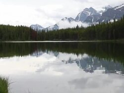 PAN across mountains, lake after storm  Stock Footage