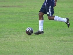 A man playing soccer on a grassy field. - Slow Motion - filmed at 240 fps Stock Footage