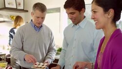 MS Mature couples preparing food together in home kitchen smiling and laughing Stock Footage