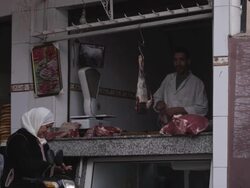 MS Shot of people walking on street and souk meat vendor selling meat / Marrakesh, Morocco Stock Footage