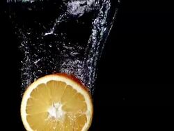 MS SLO MO Slice of orange entering into water against black background / Vieux Pont, Normandy, France  Stock Footage