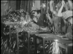 Women work on the assembly line in a factory during World War II. News Clip