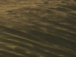 Medium Shot Tilt Down - Sand blows in the wind over desert dunes / California USA Stock Footage