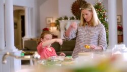 Mother and daughter have fun sprinkling flour on cookie dough in the kitchen (dolly-shot) Stock Footage