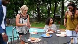 MS ZO Group of friends sitting down with food at outdoor table in backyard on summer evening Stock Footage