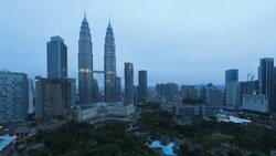 The Petronas Twin Towers and other commercial buildings are near KLCC Park in Kuala Lumpur City Center. Stock Footage