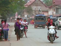 MS SLO MO Shot of small crowded road with people and vehicles moving around / Luang Prabang, Laos Stock Footage