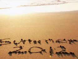 Summer 2012 written on beach during sunset, ocean surf Stock Footage