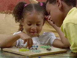CU, brother (6-7) and sister (4-5) playing Chinese checkers in living room, Westfield, New Jersey, USA Stock Footage
