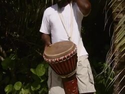 MS TU Man playing African drum on the beach / Brightown, Barbados Stock Footage