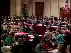 July, 1987 REAR VIEW wide shot Colonel Oliver North standing at table during Iran-Contra hearings Stock Footage