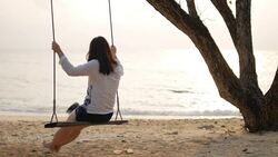 HD:Woman on swing on the beach with sea at sunset time , slow motion , relaxation concept Stock Footage