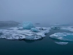 MS T/L PAN View of moving float glaciers on Jokulsarlon lake and bridge at early morning / Ireland Stock Footage