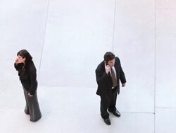  HA Businessman and businesswoman walking towards each other, then turning away and answering their cell phones / Seattle, Washington, United States Stock Footage