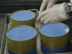 ECU gloved hand of worker pressing down on freshly filled caviar tins to seal them, RED R3D 4K,4KMSTR Stock Footage