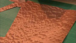 A craftsman prepares to cut a cone shape out of a piece of fabric. Stock Footage