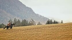 SLO MO Cowboy and cowgirl galloping up the mountain Stock Footage