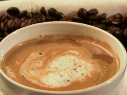 Latte and pastry on coffee beans. Stock Footage