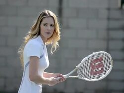 CU of a female tennis player as she hits the tennis ball backhand and water sprays. Stock Footage