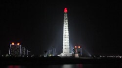 Spotlights illuminate the Tower of Juche at night in Pyongyang. Stock Footage