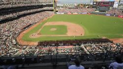 Sports fans watch the San Francisco Giants baseball game at the AT and T Park in San Francisco, California from the upper deck. Stock Footage